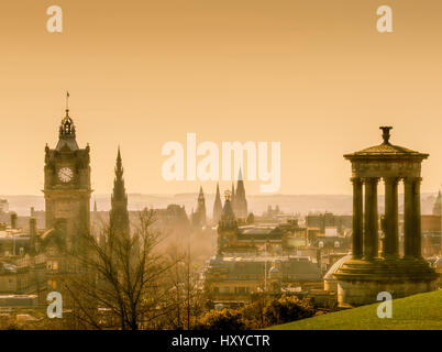 The Dugald Stewart Monument and Balmoral Hotel Clocktower with an atmospheric golden sky. Stock Photo