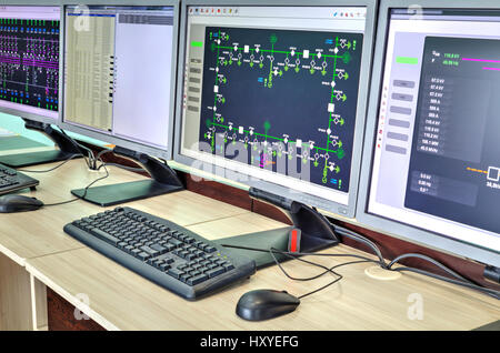 Computers and monitors with schematic diagram for supervisory, control and data acquisition in modern electrical control room Stock Photo