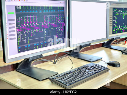 Computers and monitors with schematic diagram for supervisory, control and data acquisition in modern electrical control room Stock Photo