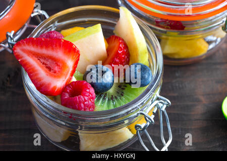 Beautiful and colorful fresh fruit salad in little jars to take away Stock Photo