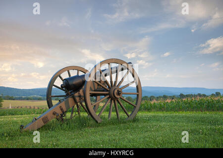 A cannon at Antietam (Sharpsburg) Battlefield in Maryland with the fence of Bloody Lane, also known as the Sunken Road in the middleground on the left Stock Photo