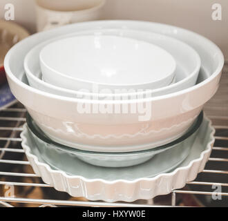Dishes stacked on shelves in a kitchen area. Stock Photo