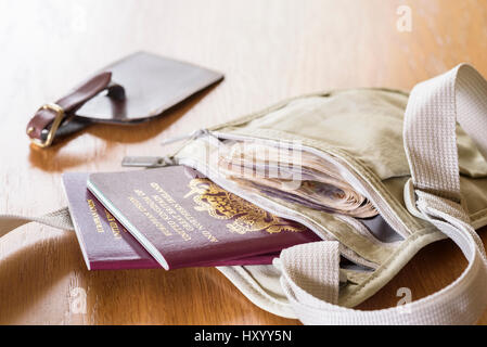 Money belt laid out on a table, with currency,  passports and luggage tag. Stock Photo