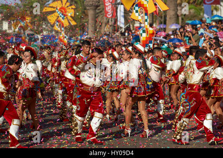 Caporales dance group in ornate red and white costume performing at the annual Carnaval Andino con la Fuerza del Sol in Arica, Chile. Stock Photo
