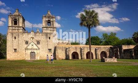 Two tourists walk along the pathway leading to Mission Concepcion in San Antonio, Texas Stock Photo
