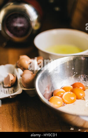 Egg Yolks in a Bowl with Flour next to Egg Shells and Bowl of Egg Whites Stock Photo