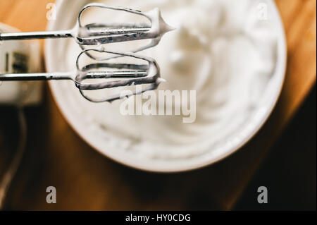 Electric mixer whisking egg whites in a glass bowl Stock Photo - Alamy