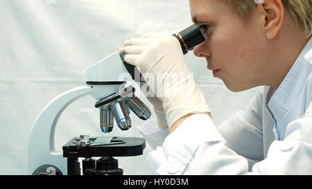 Female doctor scientist looking through microscope Stock Photo