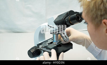 Female doctor scientist looking through microscope Stock Photo