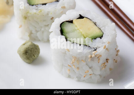 Vegan cucumber and avocado uramaki sushi rolls with wasabi. Stock Photo