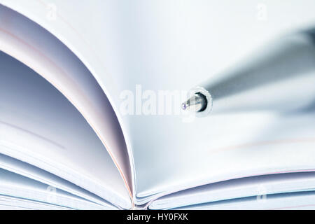 selective focus of the ball pen on opened lined diary book Stock Photo
