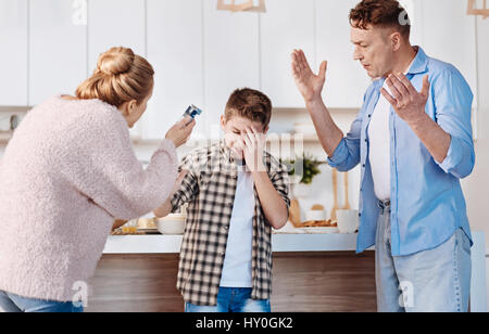 Its unhealthy. Caring parents punishing his son for smoking and giving instructions while standing in the kitchen Stock Photo