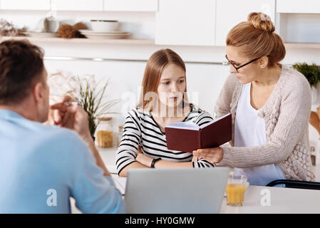 Strict mother checking marks of her daughter Stock Photo