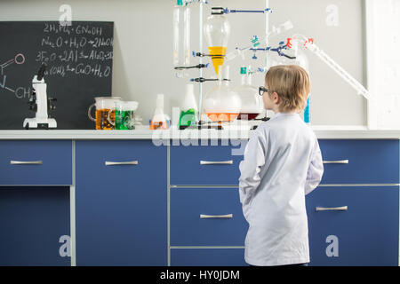 Rear view of little boy wearing lab coat in science laboratory Stock Photo