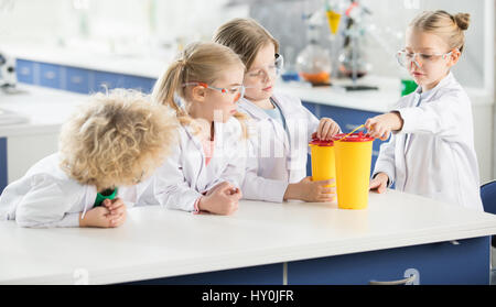 Four kids in science laboratory making experiment Stock Photo