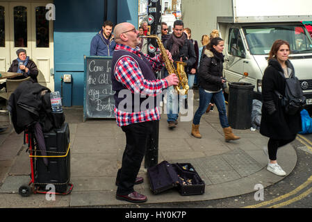 male saxaphone busker ,street busker london , saxophonist playing the saxophone on street corner Stock Photo