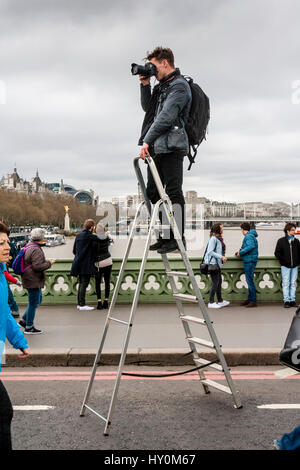 A Photographer Stands On A Step Ladder To Take Photographs Of People On Westminster Bridge A Week After The Terror Attack, London, UK Stock Photo