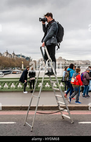 A Photographer Stands On A Step Ladder To Take Photographs Of People On Westminster Bridge A Week After The Terror Attack, London, UK Stock Photo