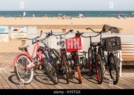 Bicycles parked on the boardwalk next to the beach in Ocean City, Maryland, USA. Bikes called 'beach cruisers' are a popular way to get around. Stock Photo