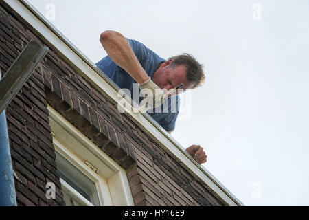 Professional painter at work on exterior of house Stock Photo