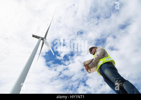 Electrical engineers working at wind turbine power generator station with laptop computer Stock Photo