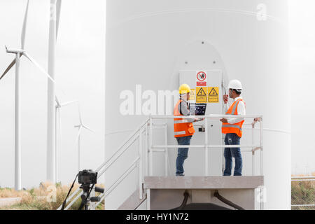 Electrical engineers and technician working in wind turbine power generator station with laptop computer Stock Photo