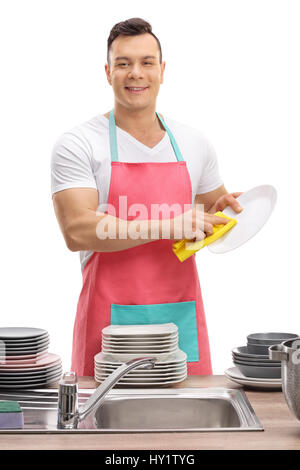 Young guy in an apron wiping dishes isolated on white background Stock Photo