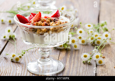 Homemade granola with fresh strawberry over vanilla yogurt. Healthy breakfast Stock Photo