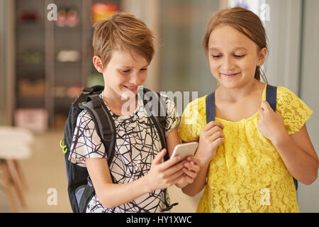 School pupils using mobilephone Stock Photo