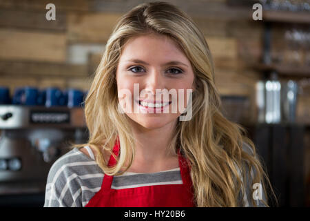 Close-up portrait of smiling young female barista in coffee shop Stock Photo