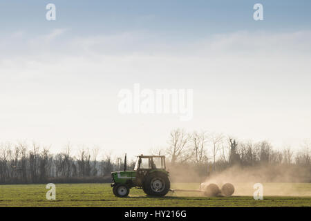 a tractor is plowing the soil Stock Photo