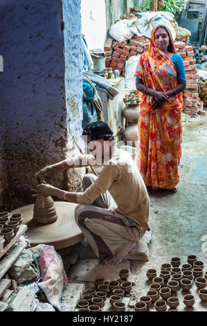 A boy spinning a potter's wheel to make small clay pots, Udaipur Stock Photo