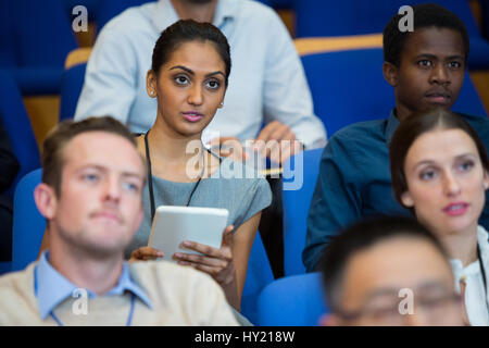 Business executive participating in a business meeting taking notes at conference center Stock Photo