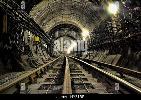 Scenic view of disused railway tracks disappearing in the tunnel. Stock Photo