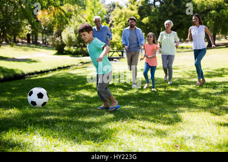 Cheerful multi generation family playing football in park Stock Photo