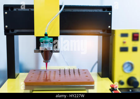 Robot holding glue syringe Injection Stock Photo