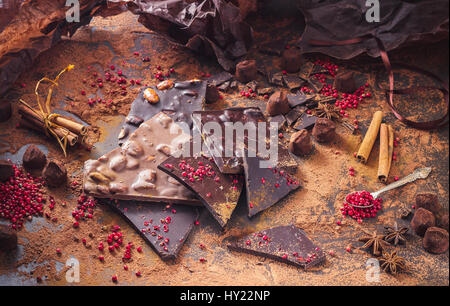 Assortment of chocolate bars, truffles, spices and cocoa powder on dark background Stock Photo