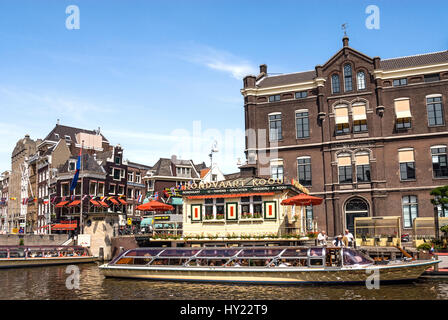 Typical sightseeing boats in a water channel in the city center of Amsterdam, Netherlands. Stock Photo