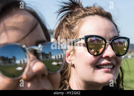 Berlin, Germany. 1st Apr, 2017. The Reichstag building reflects in the sunglasses of Kirsty and Claire (r) from Birmingham during sunshine in Berlin, Germany, 1 April 2017. Photo: Paul Zinken/dpa/Alamy Live News Stock Photo
