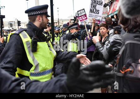 London, UK. 1st Apr, 2017. Police move anti-fascist protesters down Whitehall during a demonstration in London. Far-right groups Britain First and the EDL took to the streets in central London to protest in response to the recent Westminster terror attack, and were met by counter-demonstrations.. Credit: Jacob Sacks-Jones/Alamy Live News. Stock Photo