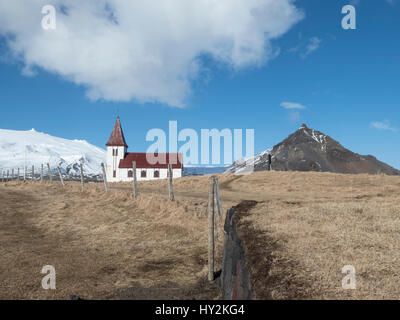 The church in Hellnar is seen in front of a snow capped mountain in the ancient fishing village of Hellnar in the Snæfellsnes peninsula, Iceland Stock Photo
