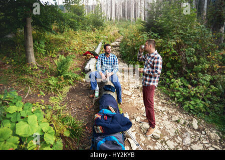 Two hikers taking a break from trekking in the forest Stock Photo