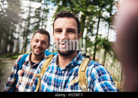 Smiling hikers taking a selfie together in the woods Stock Photo