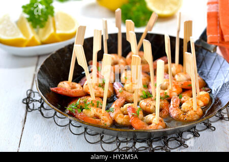 Spanish tapas - fried spicy prawns with olive oil, Sherry and garlic, served in an iron frying pan Stock Photo
