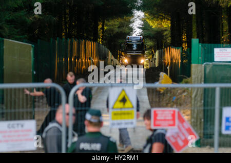 CARRICKFERGUS, NORTHERN IRELAND, UK. 09 MAY 2016 - Security team open the gates as a  convoy of lorries and vans begins to make its way out of the Infrastrata drill location in Woodburn Forest.  The site is in a major water catchment area and there has been a campaign against it, with protesters remaining at the entrance since the 15th February 2016. Stock Photo