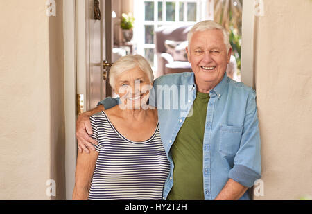 Smiling senior couple welcoming at their front door Stock Photo