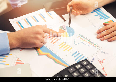 business colleague discussing paperwork graphs and charts Stock Photo