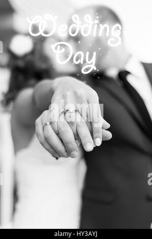 Bride and groom kissing and showing wedding rings on their fingers ...