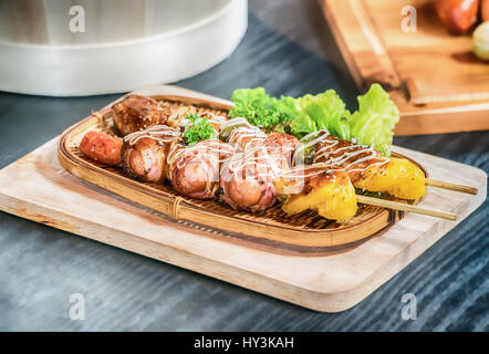 Homemade Bacon Wrapped Hot Dogs with Onions and Peppers. Stock Photo