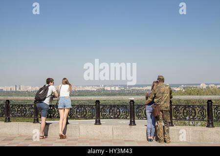 KIEV, UKRAINE - AUGUST 8, 2015: Ukrainian soldier on leave from the Eastern Ukraine conflict observing Kiev panorama with his girlfriend  Picture of a Stock Photo